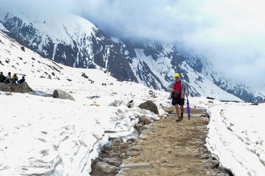 A foreigner passing through the Kedarnath trek amidst snow.