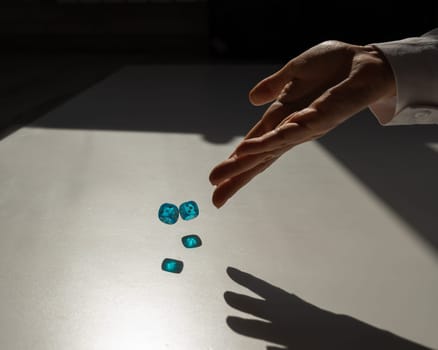 Woman throws a pair of blue transparent dice.