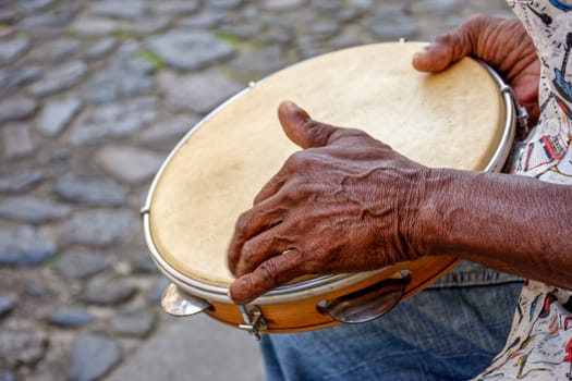 Hands and instrument of percussionist playing tambourine