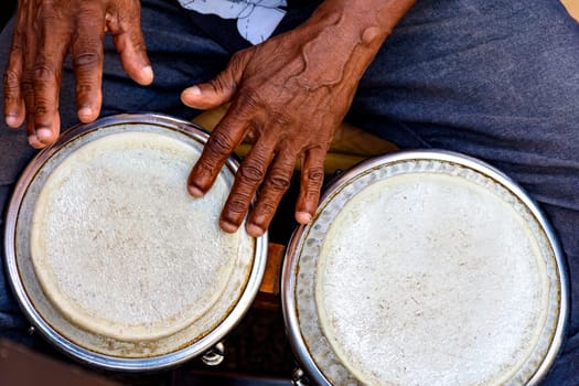 Hands and istrument of musician playing bongo