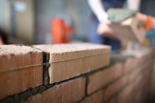 Master builder makes brickwork in house closeup