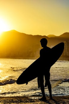 Surfer silhouette with his longboard