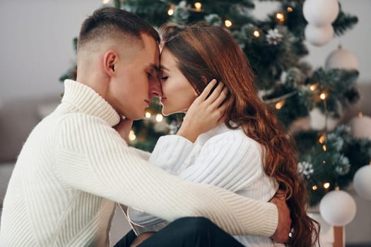 Closeness of the people. Young romantic couple celebrates New year together indoors