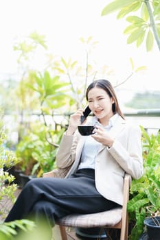 Portrait of a business woman talking on the phone and drinking coffee