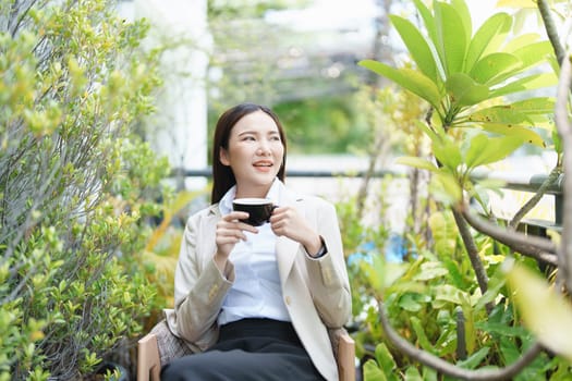 business woman sitting and drinking coffee and smiling happily