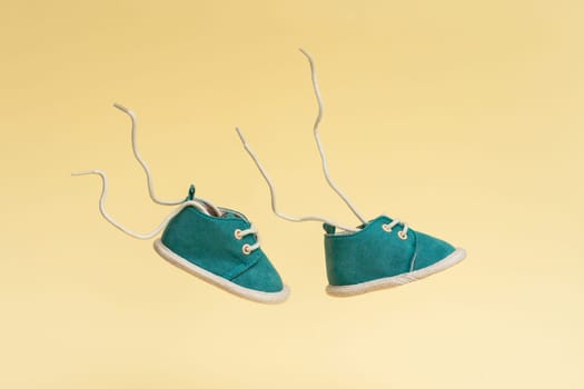 Flying baby shoes with flying laces. Newborn baby concept with levitation effect