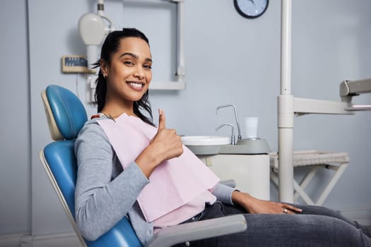 Best dentist on the block. Portrait of a young woman showing thumbs during her dental appointment