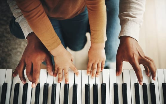 Hands, parent and kid learning piano as development of skills together and bonding while making music in a home. Closeup, musical and child playing a song on an instrument and father teaching