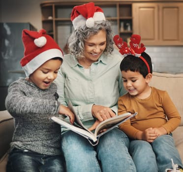Christmas, photo album or children with a happy grandmother and kids looking at photographs during festive season. Family, love or celebration with a woman and grandchildren holding a picture book.
