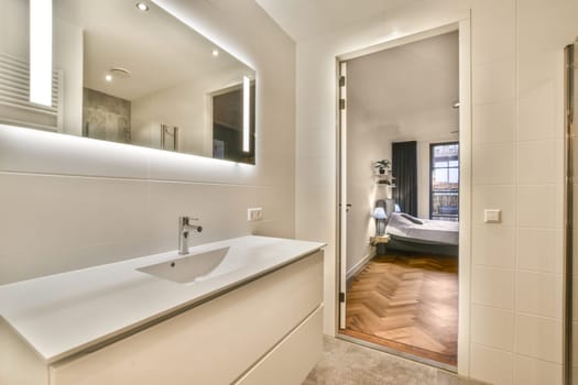 a bathroom with a sink and mirror and a bedroom