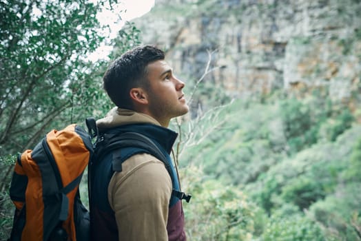 Wander without purpose or reason. a young man hiking through the mountains.