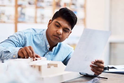 Nothing goes unnoticed. a young architect designing a building model in a modern office.