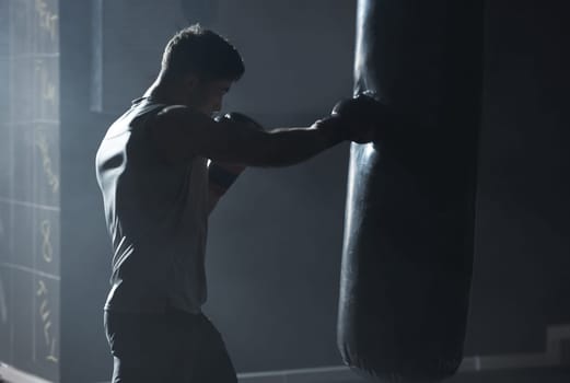 With self discipline comes success. a young man practicing his boxing routine at a gym.