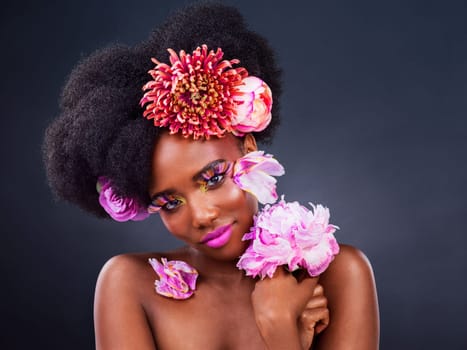 Flowers is the only accessory you need. Studio shot of a beautiful young woman posing with flowers in her hair.
