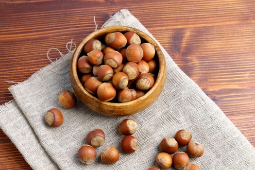 Hazelnuts on wooden table. Heap or stack of hazelnuts.