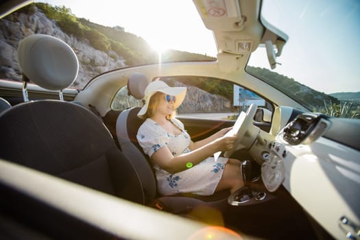 Young woman drive and having fun in cabrio against mountains - travel and summer voyage nature concept