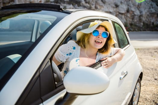 Young woman drive and having fun in cabrio against mountains - travel and summer voyage nature concept
