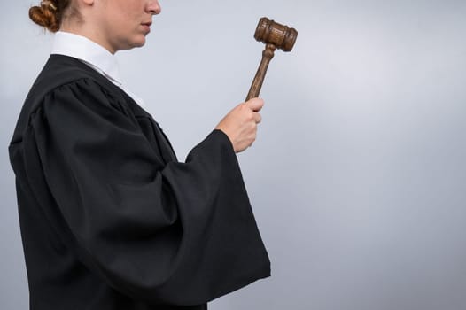 Steadfast female judge in a robe holding a court gavel.