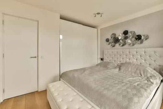 a bedroom with a white bed and a white wardrobe