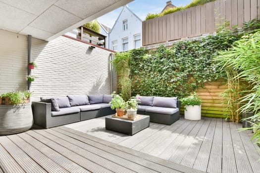 a patio with couches and plants on a deck