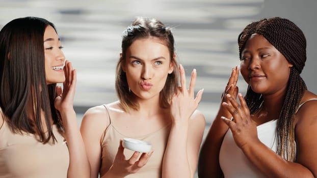 Interracial women applying moisturizing face cream