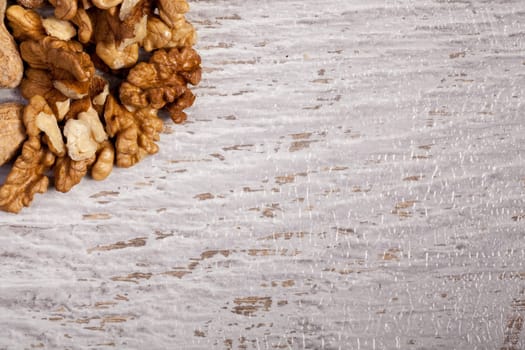 Mix of different type of nuts on wooden background