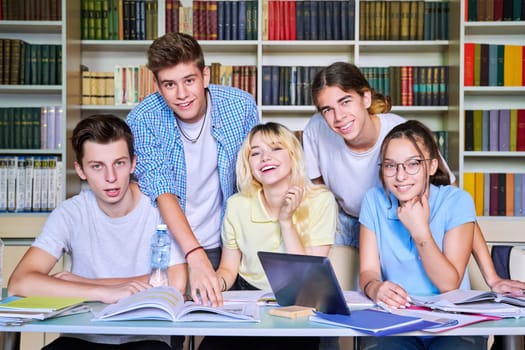 Group of teenage students study in library class.