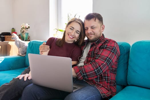Happy smiling middle aged family couple looking at laptop screen together