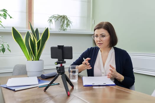 Woman psychologist, professional counselor giving video consultation, recording video broadcast