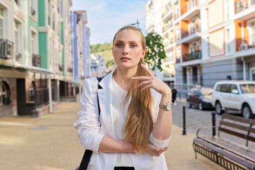 Outdoor portrait of talking young business woman in city