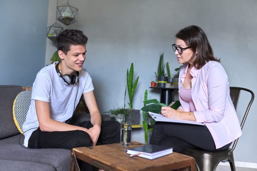 Boy teenager gives interview to woman psychologist in office