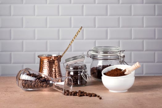 Coffee beans and ground coffee in glass and porcelain containers.