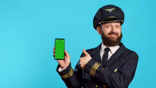 Smiling male aviator using telephone with greenscreen