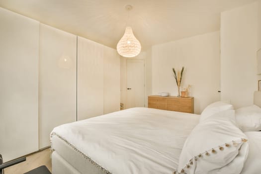 a bedroom with a white bed and a white wardrobe