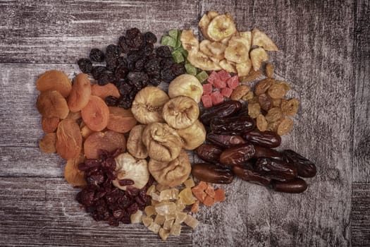 Different type of raw dried fruits on wooden type background