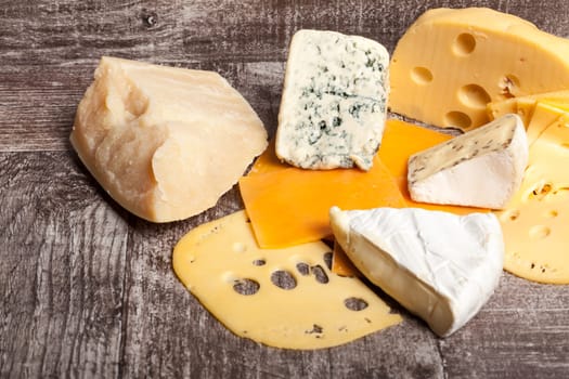 Different type of cheese on wooden background