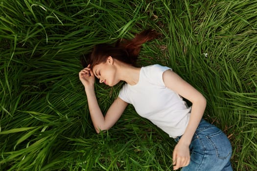 woman lies in tall grass falling asleep in nature