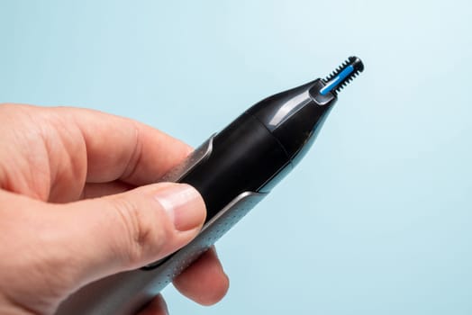 Top view of nose and ear hair trimmer isolated on blue background