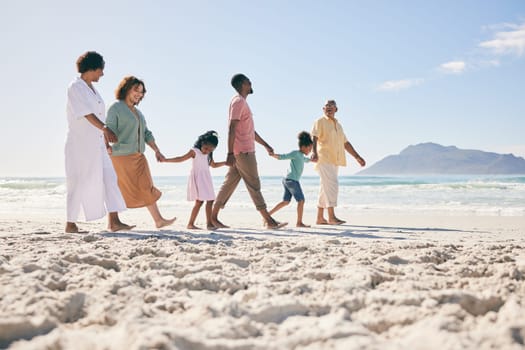 Holding hands, vacation and family on beach, walking and break to relax, happiness and ocean water waves. Grandparents, father and mother with grandkids, seaside holiday and quality time together