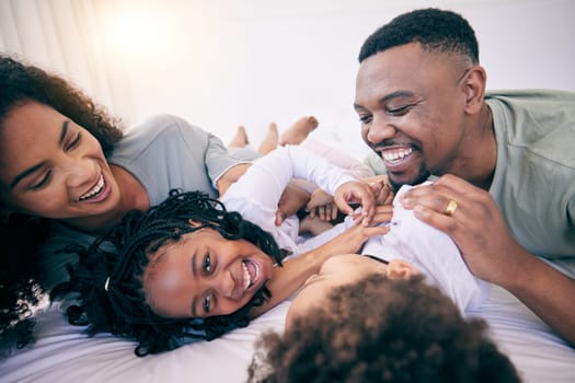 Laugh, tickle and morning with black family in bedroom for wake up, bonding and affectionate. Weekend, smile and care with parents and children at home for playful, funny and free time together