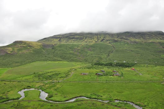 Scenic view of a river flowing between grass valleys in Iceland