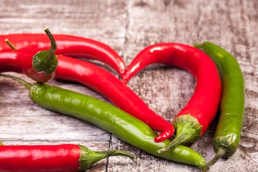 Spicy Red and green pepper on wooden background