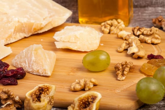 Cheese, honey and grape on wooden background