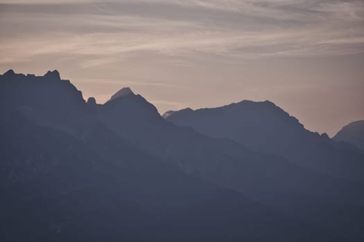 Mountains silhouette with peaks in the morning mist Saalfelden, Salzburg, Austria