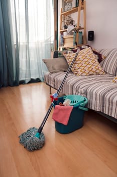 mop and bucket with cleaning products and a rag