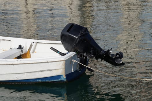 stern of a small boat with a motor on the water