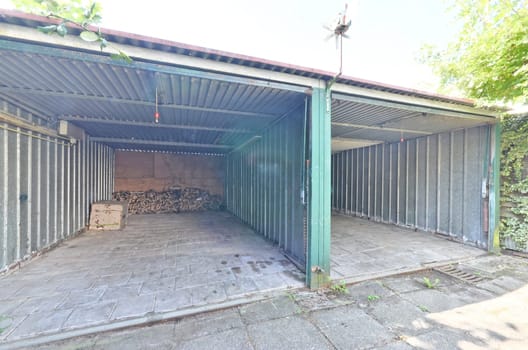 an open metal garage with a brick courtyard