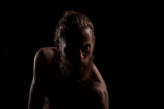 Angry hipster in dramatic photo on black background