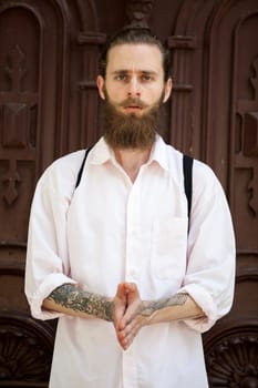 Portrait of tattooed hipster with long beard