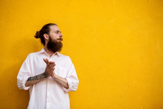 Cool bearded hipster on yellow wall